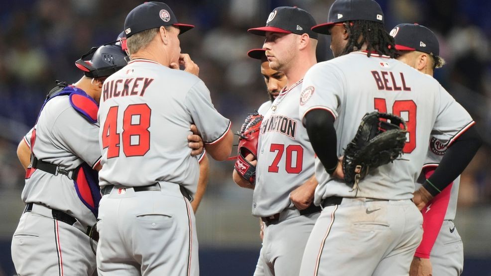 Washington Nationals pitching coach Jim Hickey (48) talks with starting pitcher Mitchell Parker (70) during the fifth inning of a baseball game against the Miami Marlins, Friday, April 11, 2025, in Miami. (AP Photo/Lynne Sladky)
